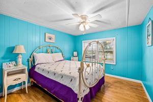 大西洋滩Fanci's Hideout的蓝色卧室配有床和吊扇
