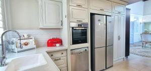 阿卡Mina Akko sea view的厨房配有白色橱柜和不锈钢冰箱