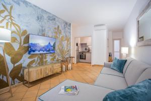 罗马Domus Regola Luxury Apartment的客厅配有沙发和墙上的电视