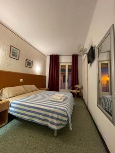 滨海托萨P&R hostals Maria Rosa的一间卧室配有一张带蓝白条纹毯子的床