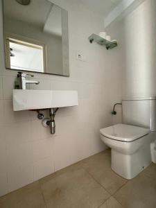 滨海托萨P&R hostals Maria Rosa的浴室设有白色的卫生间和镜子