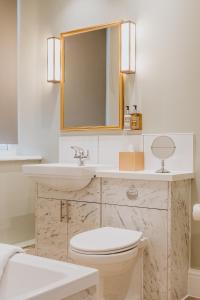 马特洛克Grouse & Claret, Matlock by Marston's Inns的一间带水槽、卫生间和镜子的浴室