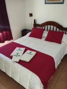 科洛尼亚-德尔萨克拉门托罗米酒店的一张带两个白色和红色枕头的床