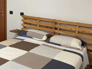 Villa MinozzoIl Golfarone的一间卧室配有一张大床和木制床头板