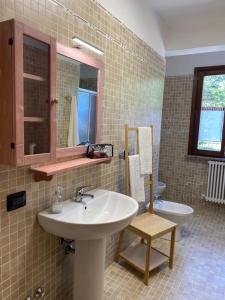 Villa MinozzoIl Golfarone的一间带水槽、卫生间和镜子的浴室