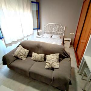塞维利亚Apartamento FIBES edificio LUX SEVILLA的客厅配有沙发和1张床