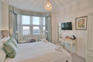 滨海绍森德海滩旅馆的卧室设有一张白色大床和一扇窗户。
