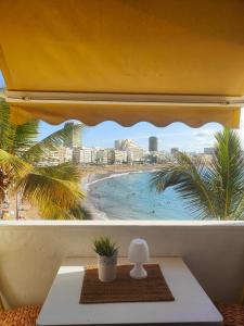 大加那利岛拉斯帕尔马斯Francisco's Holiday Home的享有海滩和建筑景致的窗户。