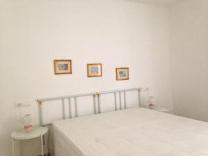 TroiaB&B 208的卧室配有一张床,墙上挂有两张照片