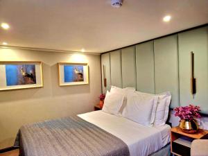 阿威罗Costa do Sal Hotel Boat Lounge的卧室配有带白色枕头的大床