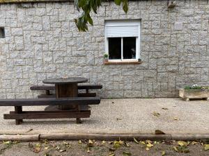 VilafantLes Oliveres - casa- apartament的砖墙旁的野餐桌,带窗户