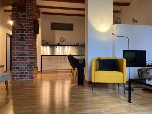 爱尔福特ARYVE JC Studio - Altstadtnahes Boutique Apartment inklusive kostenfreiem Parkplatz的一间带黄色椅子的客厅和一间厨房