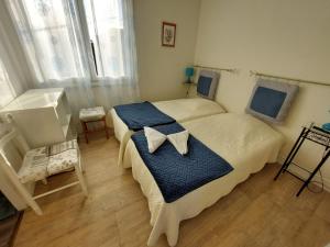 Saint Paul de Loubressac奥夏梅都拉瓦特酒店的一间小卧室,配有两张床和窗户