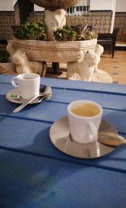 奇皮奥纳HOSTAL LA CRUZ 1872的坐在桌子上喝杯咖啡