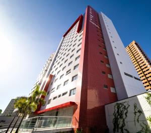 福塔莱萨Stop Way Hotel Fortaleza的一座高大的红色和白色建筑
