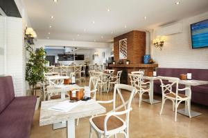 内尔哈Hotel Villa Flamenca的餐厅设有白色的桌椅和柜台
