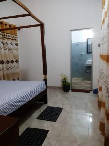 米瑞莎Bisandu guesthouse的一间卧室配有一张床,浴室设有淋浴。