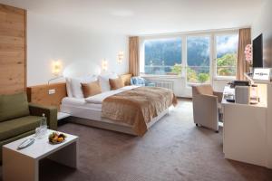 英格堡Hotel Waldegg - Adults only的一间卧室设有一张床和一间客厅。