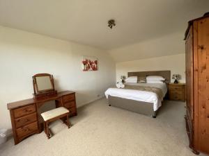 波廷斯凯尔Roslin的一间卧室配有两张床、镜子和梳妆台