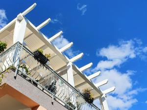 特里班Apartmani Villa Lilliana的一座种植了盆栽植物的建筑的阳台