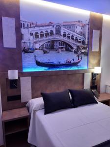 托梅略索HOTEL BOUTIQUE DOÑA MANUELA的一间卧室,配有一幅桥画和一张床