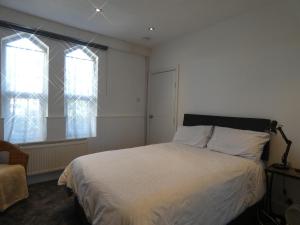 SandycroftVictoria Villas的一间卧室设有一张床和两个窗户。