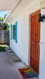 凤凰城Newly Remodeled Mid Century Saguaro House (36)的一间房子的大门,旁边是五颜六色的地毯