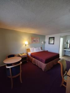 威尔科克斯威尔科克斯8号汽车旅馆的酒店客房配有一张床铺和一张桌子。