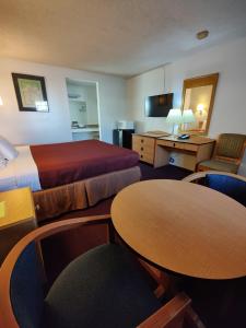 威尔科克斯威尔科克斯8号汽车旅馆的酒店客房带两张床和一张桌子以及椅子。