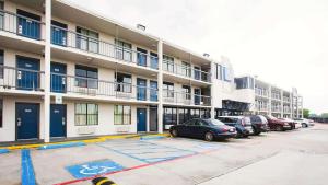 休斯顿Motel 6 Houston, TX - Medical Center - NRG Stadium的公寓大楼前的停车位