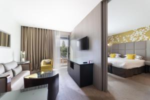 里昂Crowne Plaza Lyon - Cité Internationale的酒店客房,配有床和沙发