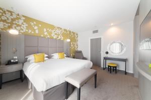 里昂Crowne Plaza Lyon - Cité Internationale的卧室配有一张带黄色枕头的大型白色床。