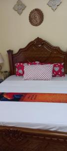 姆特瓦帕Stars Maisonette的一张带粉红色枕头的木头床头板的床