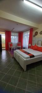 姆特瓦帕Stars Maisonette的一间大卧室,配有大床和红色窗帘