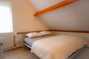 韦默尔丁厄Huisje 11 Wemeldinge的一间卧室配有一张带两个枕头的床