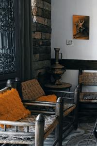 OuzoudTitrite Ouzoud的一间客房配有两把椅子和一张桌子,并提供橙色的毯子