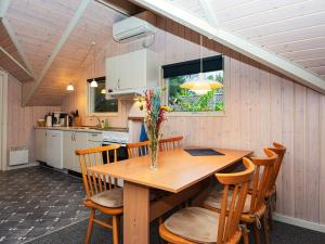 安斯艾厄Holiday home Ansager XLIII的厨房以及带木桌和椅子的用餐室。