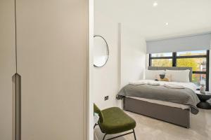 伦敦Executive 1 & 2 Bed Apartments in heart of London FREE WIFI by City Stay Aparts London的一间卧室配有一张床和一把绿色椅子