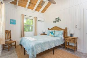 Forbes HillSunset Cove的一间卧室设有床、两张桌子和一扇窗户