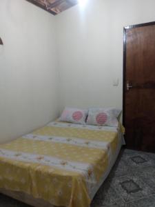卡马萨里Refúgio sossego (casa de campo)的一间卧室配有一张床和一扇木门