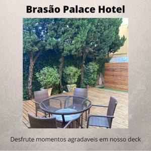 普鲁登特总统城Brasao Palace Hotel的一个带玻璃桌和椅子的庭院