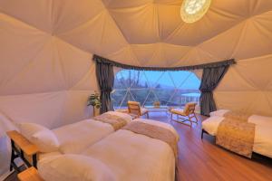 富士吉田市Mt.Shakushi Gateway Camp的一间卧室设有四张床和大窗户