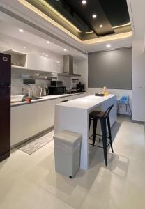 台南威尼斯民宿的厨房配有白色柜台和黑色冰箱。