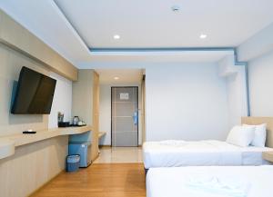 清莱Sann Hotel的酒店客房设有两张床和一台平面电视。