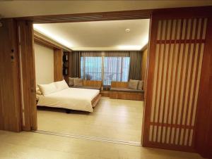 安平区台南安平Viva漁樂活民宿的一间卧室配有一张床,另一间卧室配有窗户