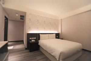台北城美行旅的卧室配有白色的床和墙壁