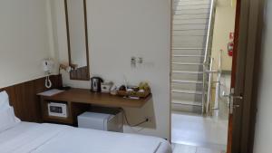 曼谷Baan Wanchart的一间卧室配有一张床、一张书桌和一个楼梯