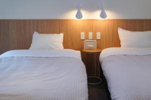 SanukiBeach SPA TSUDA 0 Cero棟的酒店客房,配有两张带白色床单的床