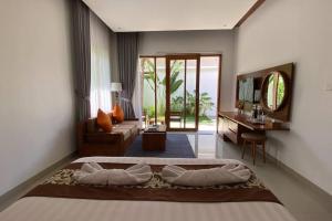 珀尼达岛Nau Nusa Villa的一间卧室配有一张床,客厅配有电视