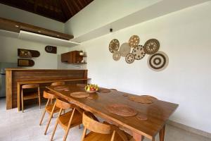 珀尼达岛Nau Nusa Villa的一间带木桌和椅子的用餐室